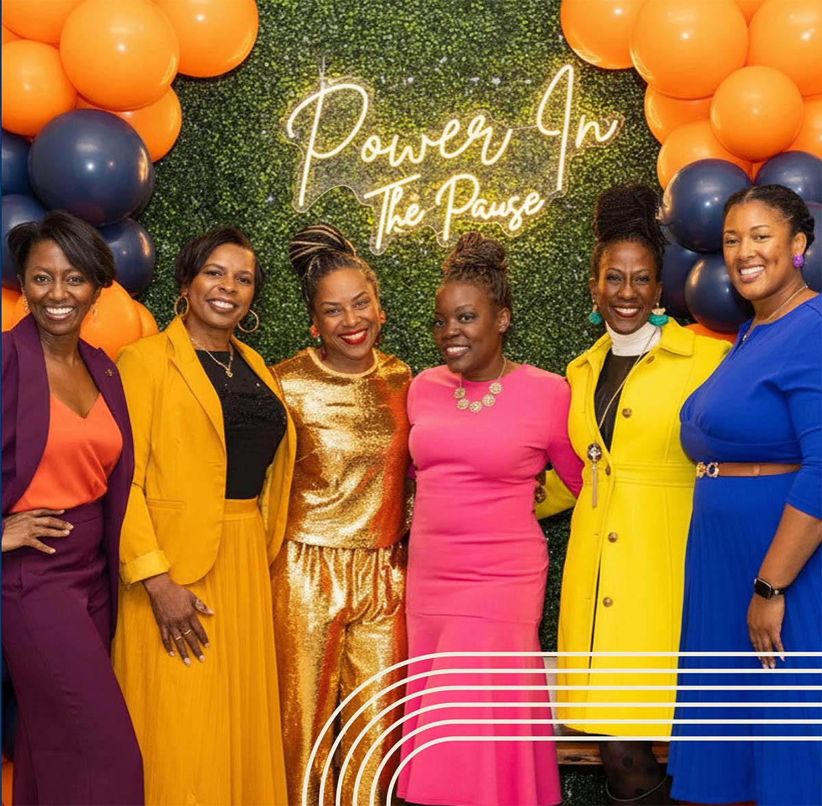 Group of women in front of a Power in the Pause neon lights.